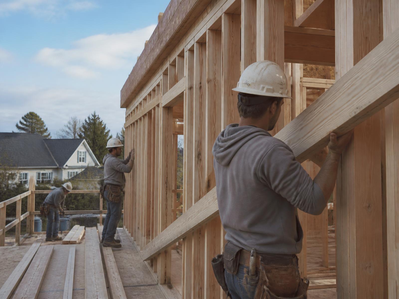Construction crew framing a residential build on a clear morning